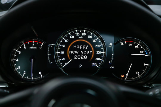 Close up Instrument automobile panel with Odometer, speedometer, tachometer, fuel level, which says Happy New Year 2020. The concept of the new year and Christmas in the automotive field.