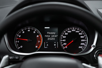 Close up Instrument automobile panel with Odometer, speedometer, tachometer, fuel level, which says Happy New Year 2020. The concept of the new year and Christmas in the automotive field. - obrazy, fototapety, plakaty