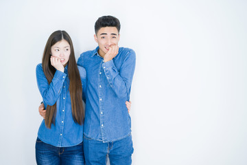 Naklejka premium Beautiful young asian couple over white isolated background looking stressed and nervous with hands on mouth biting nails. Anxiety problem.