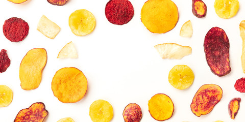 A panorama of dry fruit and vegetable chips, healthy vegan snack, on a white background, forming a...
