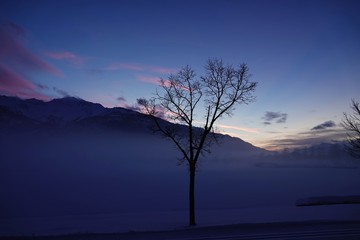 Fototapeta na wymiar beautiful sunset on a frozen lake with fog