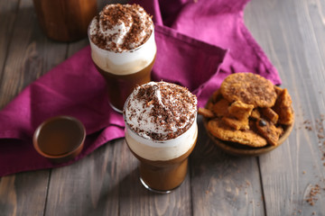 Glasses of tasty frappe coffee on wooden table