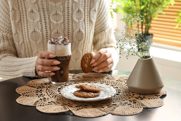 Woman drinking tasty frappe coffee with cookies in cafe