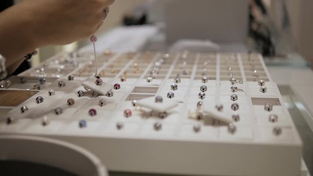 At the jeweler, sales women is  presenting luxury jewelry. Concept:  luxury jewelry, an idea for a Christmas gift, black friday sales.