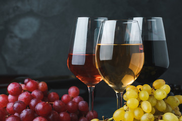 Glasses of different wine on dark background, closeup