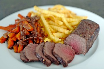 delicious fillet from venison with vegetables and fries