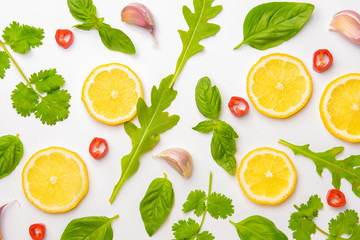 Lemon slices with different herbs on white background