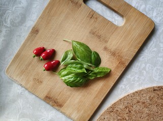 basil and tomatoes on wooden board