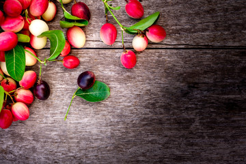 Closeup pile of fresh Carissa carandas Linn or Karanda ,Carunda ,Karonda , Bengal currants ,Koromcha fruits isolated on wooden board background.  Healthy food,fruit concept. Top view. 