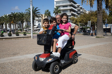 Grandfather with his grandchildren on a motorized cair