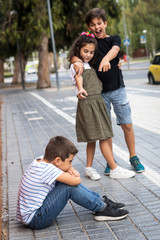 Two children bullying another in the schoolyard