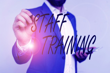 Text sign showing Staff Training. Business photo showcasing program that helps employees learn specific knowledge Businessman in blue suite and white shirt pointing with finger in empty space