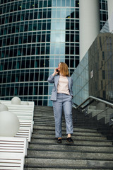 business woman talking on the phone in the background of an office building