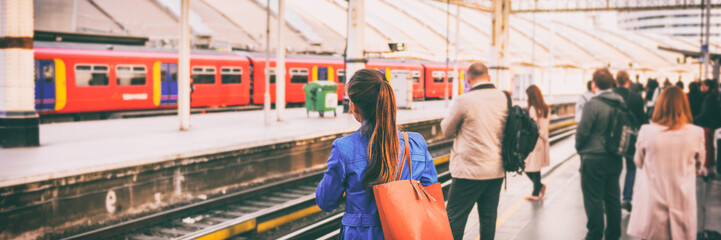 Commuters going to work waiting at train station platform in London city, UK, Europe banner panorama. Train public transport commuting network woman passenger with orange purse panoramic banner. - obrazy, fototapety, plakaty