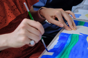 A girl paints a picture. Female hand with a brush for painting close up