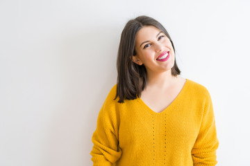 Obraz premium Beautiful brunette young woman smiling confident and cheerful over isolated white background wearing casual yellow sweater