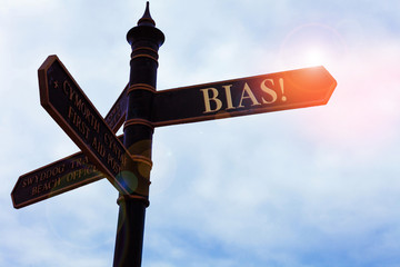 Handwriting text writing Bias. Conceptual photo inclination or prejudice for or against one demonstrating group Road sign on the crossroads with blue cloudy sky in the background