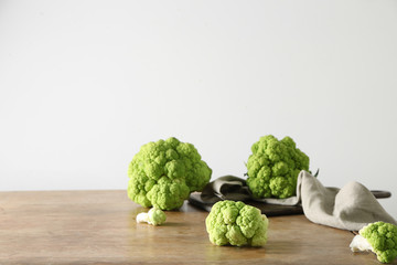 Tasty fresh cauliflower cabbage on wooden table against light background