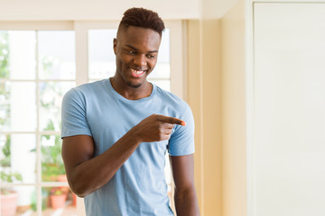 Handsome african young man smiling cheerful pointing with arms and finger to the side