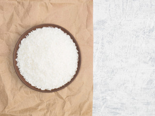 Spices help maintain good health and improve appetite, top view on craft paper and concrete background. Coconut flakes in clay plate. Modern apothecary, naturopathy and ayurveda concept.