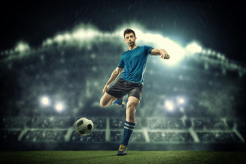 Plakat Soccer player in action on night stadium background