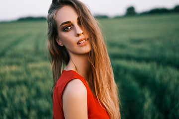 Portrait of beautiful young woman posing outdoors in summer sun