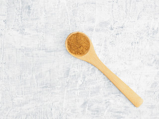 Spices help maintain good health and improve appetite, top view on white concrete background. Masala in wooden spoon. Modern apothecary, naturopathy and ayurveda concept.