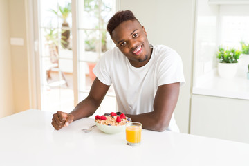 Handsome african american man eating heatlhy cereals and berries as breakfast