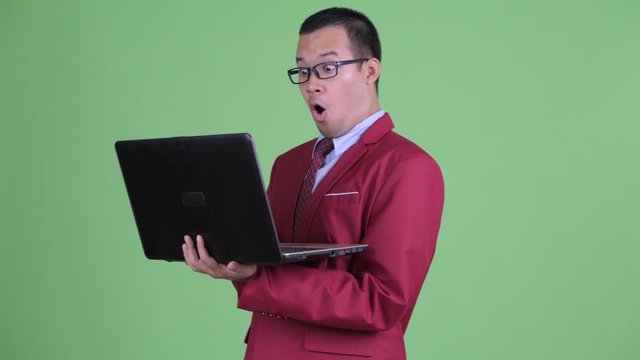 Happy Asian businessman using laptop and watching adult videos