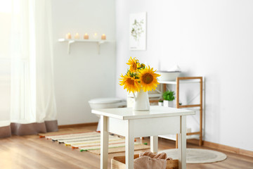 Beautiful sunflower flowers on table in bathroom