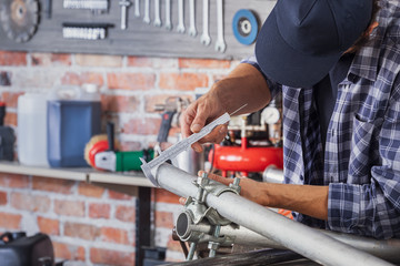 Metalworker taking measurements on a metal pipe