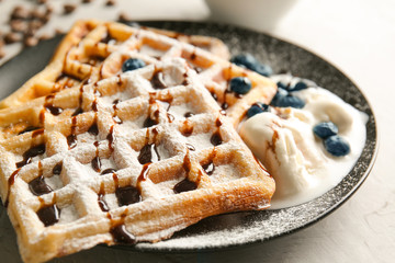 Tasty waffles with chocolate, ice-cream and berries on plate, closeup