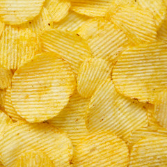 Salted wavy potato chips, overhead view. Top view, from above, flat lay. Closeup.