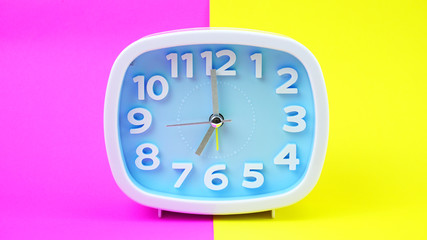 Blue Alarm clock on Yellows Pink background, Copy space for your text, Time concept.