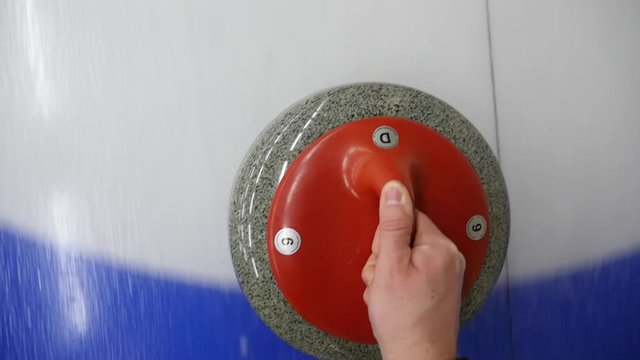 Curling winter sport. POV, personal point of view of player sliding curling stone on a sheet of ice. Concept: Winter olympic sport, winter team games.