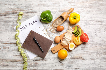 Sheet of paper with diet plan, measuring tape and healthy products on white wooden background