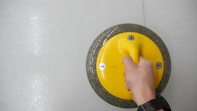 POV, personal point of view of player sliding curling stone on a sheet of ice