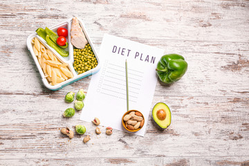Sheet of paper with diet plan and healthy food on white wooden background
