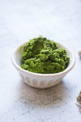 Green fresh pesto dip paste with spinach and nuts. Vegan or vegetarian food.