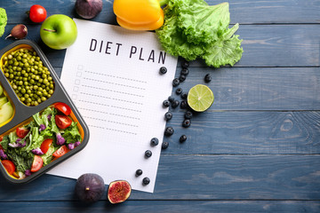Sheet of paper with diet plan and healthy products on wooden table - obrazy, fototapety, plakaty