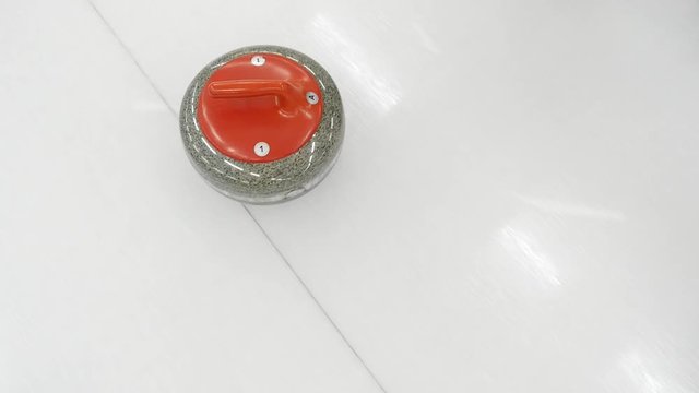Curling stone is sliding on the pebbled ice sheet. Concept: winter olympic sport, team game