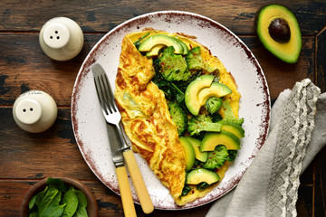 Omelette stuffed with green vegetables : broccoli, avocado and baby spinach.Top view with copy...