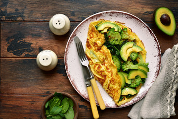 Omelette stuffed with green vegetables : broccoli, avocado and baby spinach.Top view with copy space.