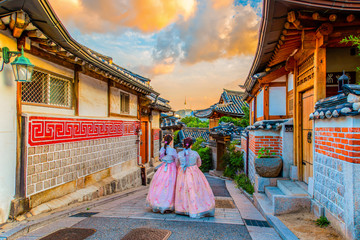 The atmosphere before the sunset at Bukchon hanok village, tourists dressed in hanbok to take pictures and watch the view because it is beautiful. - obrazy, fototapety, plakaty