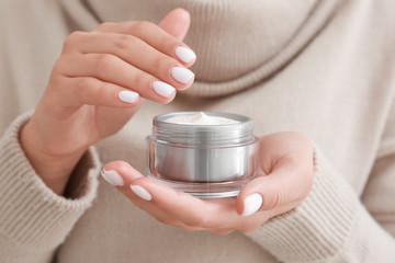 Woman with jar of cosmetic cream, closeup