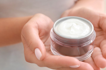 Woman with jar of cosmetic cream, closeup