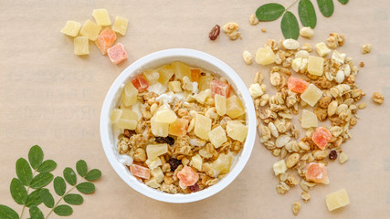 granola with candied fruit in a ceramic bowl