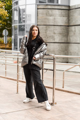  pretty girl in jacket and black pants walking down the street