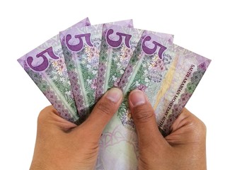 Hands holding 5 Saudi riyal banknotes isolated on white background. 