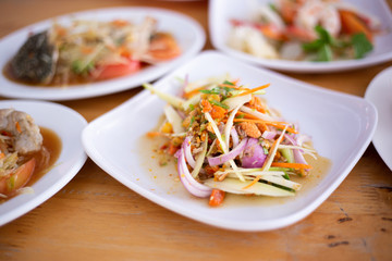 Closeup eggs crab spicy salad papaya, Som Tum and other food in Thai local restaurant.